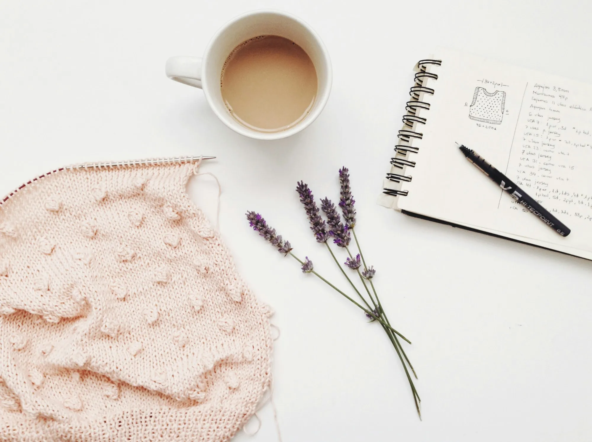 Notizbuch, Kaffee und Lavendel auf einem hellen Tisch